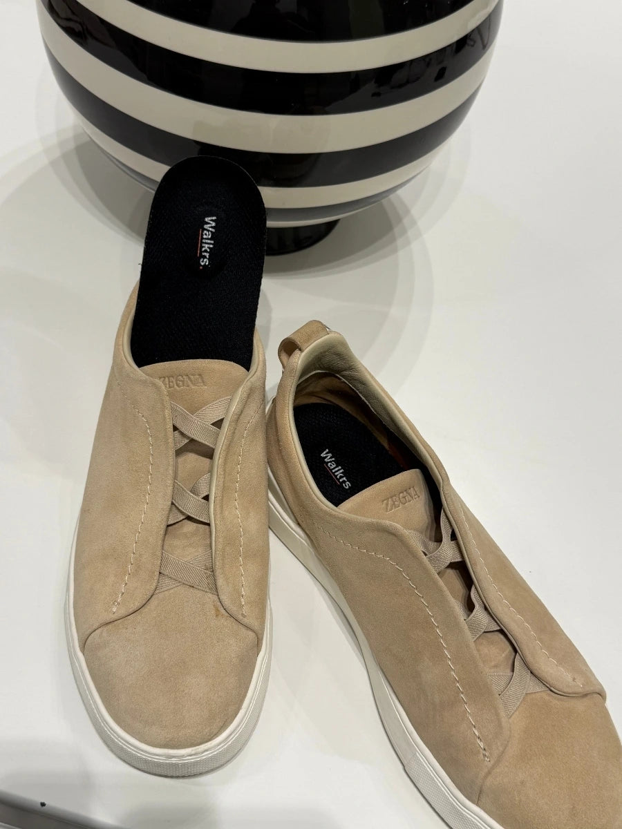 Walkrs insole shown next to a pair of suede sneakers